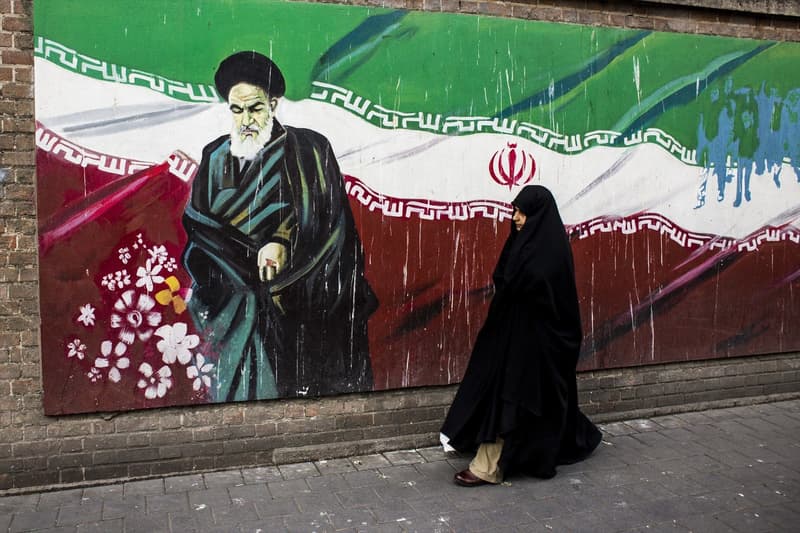 Una dona al costat d'un mural de l'aiatol·là Khomeini a Teheran