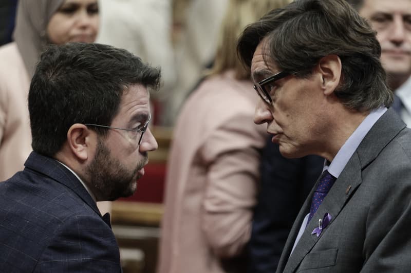 El presidente de la generalitat, Pere Aragonès (D), i el primer secretario del PSC, Salvador Illa (D), hablan durante una sesión en el hemiciclo del Parlament.