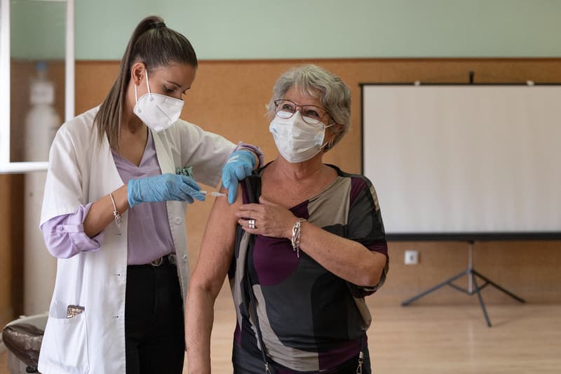 Una enfermera vacuna a una mujer de la gripe