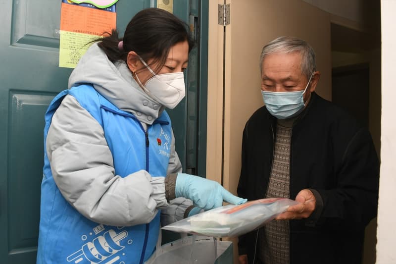 Una treballadora lliura un paquet d'assistència al districte d'Haidian, a Pequín