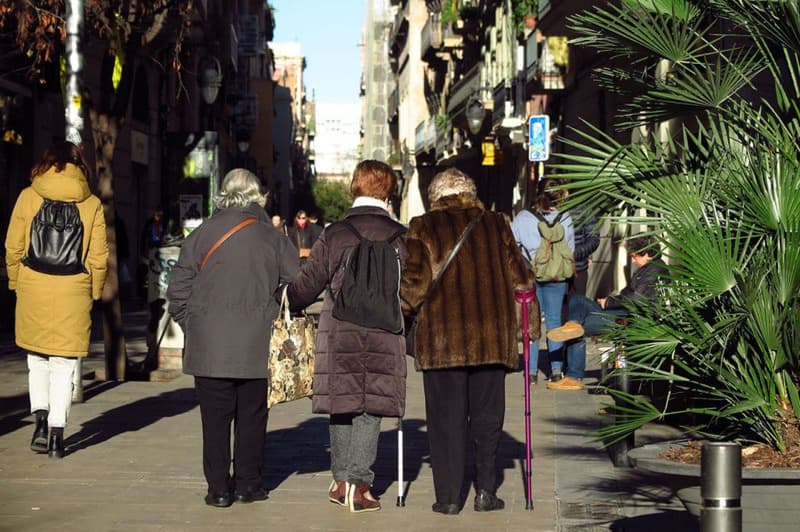 Personas mayores paseante por la calle de Asturias de Barcelona, en el barrio de Gracia