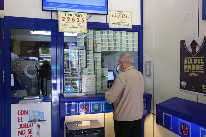 Un home compra loteria en una Administració de Loterías y Apuestas del Estado