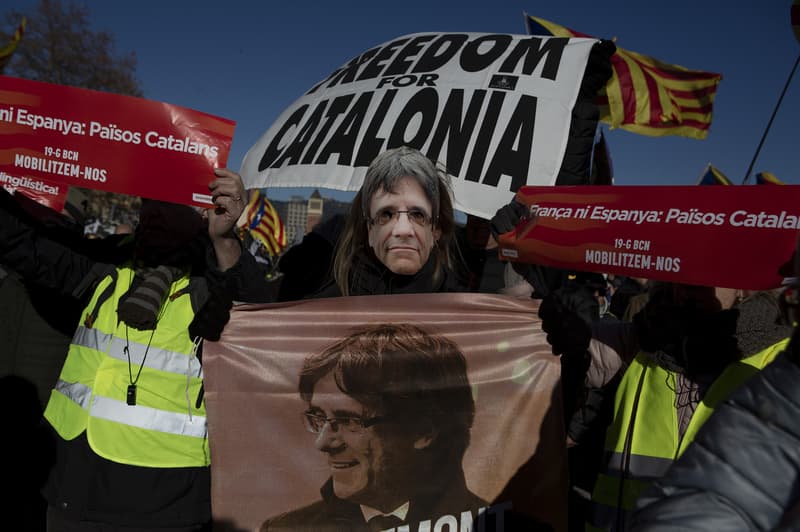 Una dona amb una màscara de Puigdemont es manifesta a la protesta contra la cimera entre Sánchez i Macron