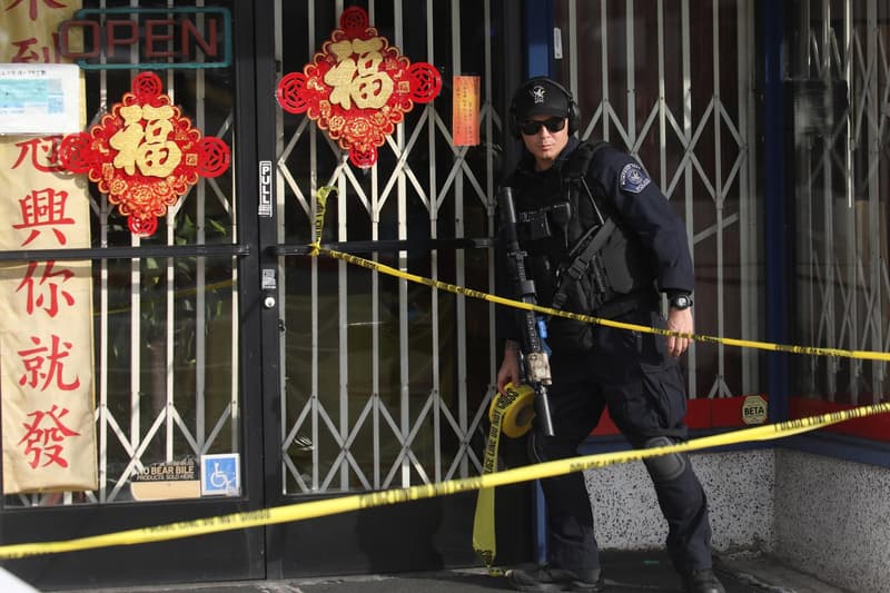 Un oficial de policía de Monterey Park con cinta de la escena del crimen después del tiroteo masivo