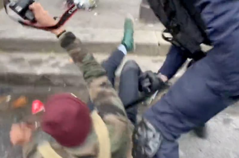 Captura de pantalla on es pot veure com un policia dona un cop de porra a un fotògraf