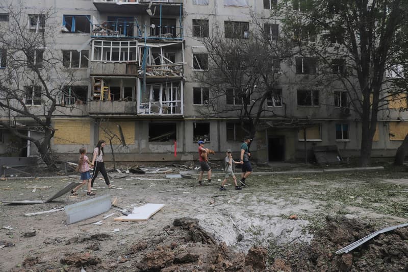 Persones passen davant un edifici residencial fet malbé en els recents bombardejos a la ciutat de Bajmut.