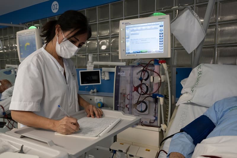 Una treballadora de l'Hospital Clínic apunta dades d'un pacient a mà arran del ciberatac