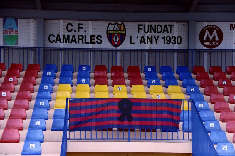 Una pancarta amb un crespó negre a la grada de l'estadi del CF Camarles | Jordi Marsal / Mar Rovira (ACN)