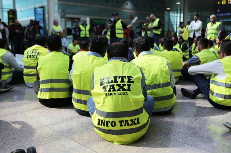 Un grup de taxistes es reuneixen durant una concentració dins de les instal·lacions de la T1 de l'aeroport de Barcelona