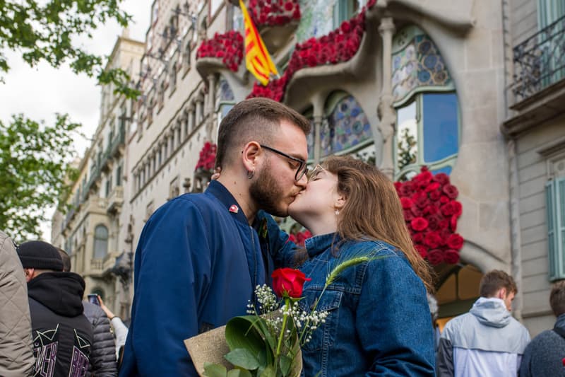 Una pareja, ella con una rosa roja, se besa en Sant Jordi