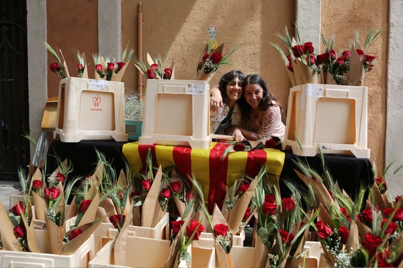 Dos vendedoras sonríen rodeadas de rosas