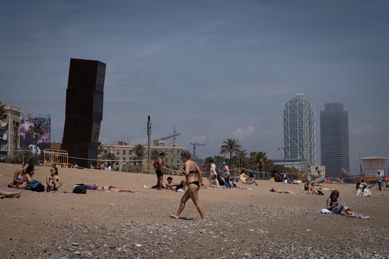 Varies persones prenen el sol a la platja de la Barceloneta