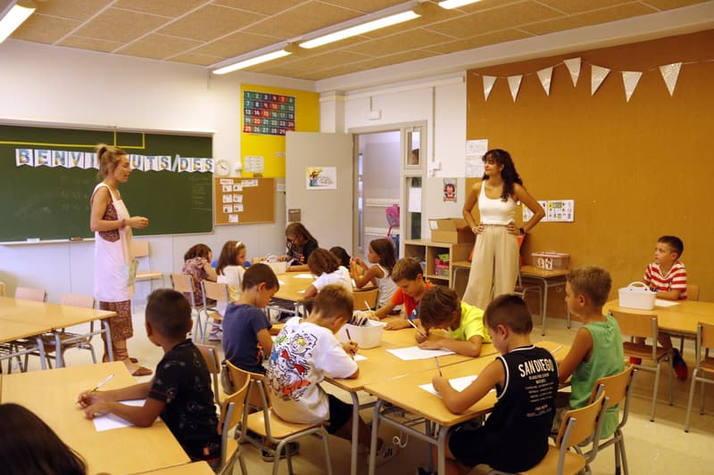 Alumnos de segundo de primaria de la escuela Países Catalanes de Lleida, durante la hora de ocio educativo, con una de las monitoras.