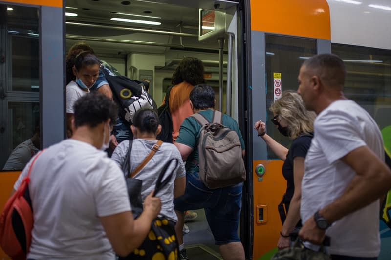 Usuaris pujen un tren de Rodalies a l'estació de Sants a Barcelona