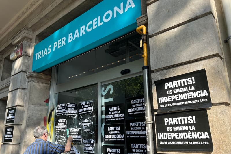 Un señor retira los carteles de la sede electoral de Xavier Trias