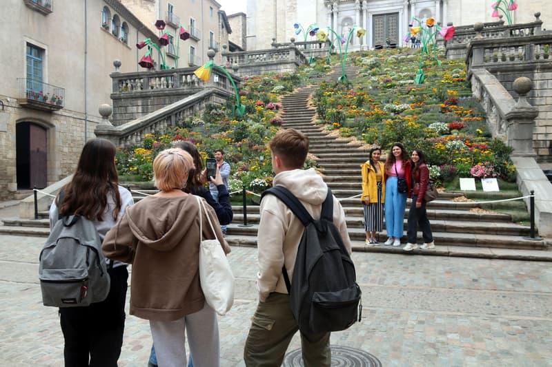 Turistes davant del muntatge floral de les escales de la Catedral de Girona | Xavier Pi / ACN