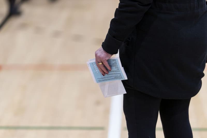 Una mujer se espera para votar con el voto y la información del censo en la mano