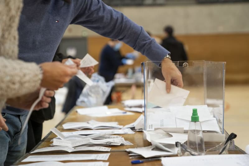 Un miembro de una mesa saca los votos de una urna para hacer el recuento