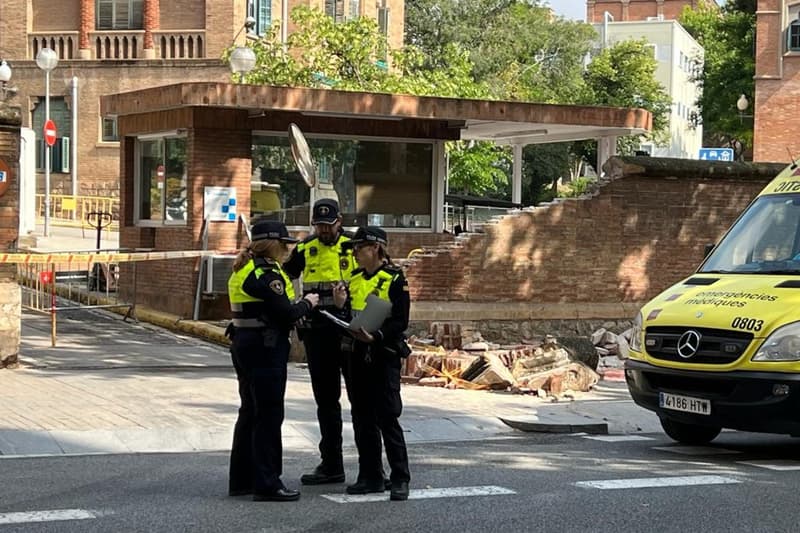 Agentes de la policía delante del muro caído del recinto modernista del Hospital de Sant Pau de Barcelona después de que un camión de gran tonelaje chocara | ACN