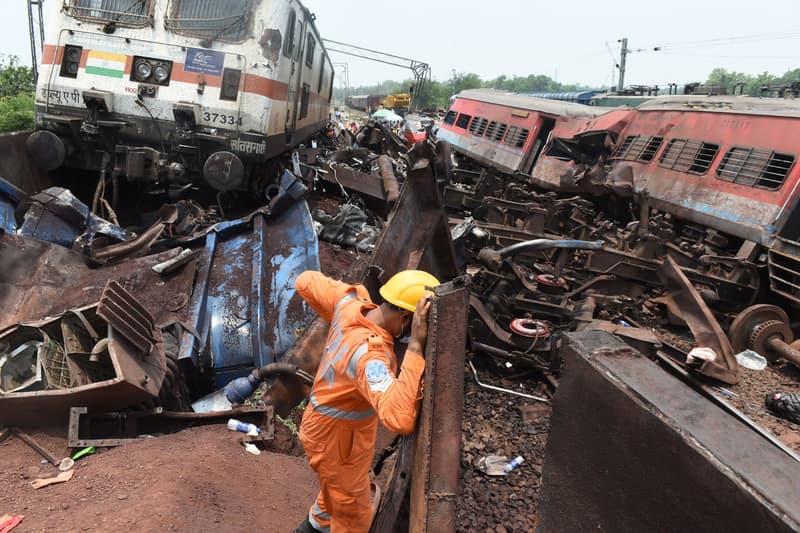 Un operari, entre les restes de l'accident ferroviari a l'Índia