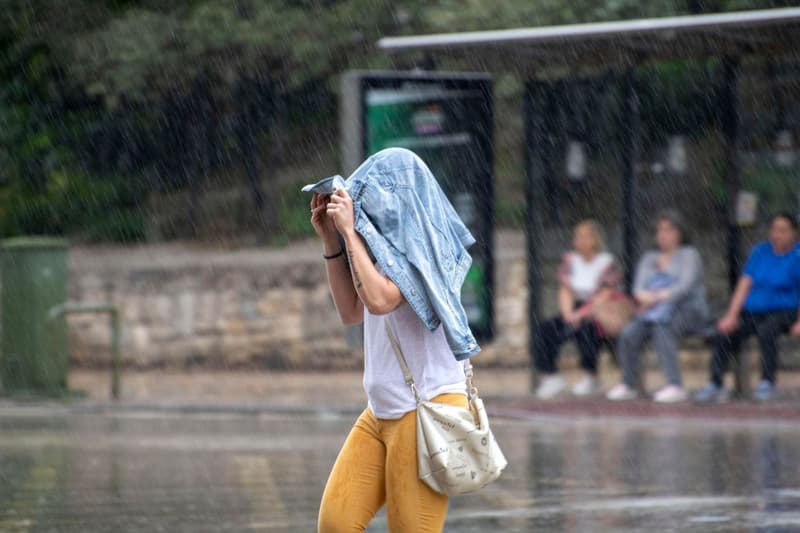 Una mujer anda|camina bajo la lluvia