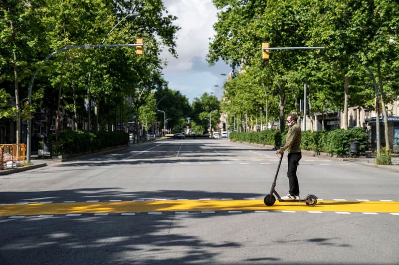 Un hombre en patinete eléctrico cruza la calle de Pau Claris