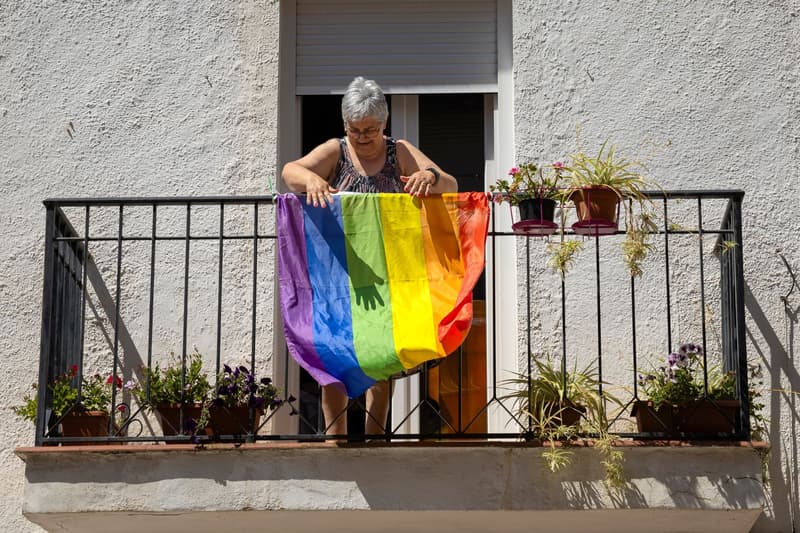 Una veïna col·locant la bandera LGTBIQ+ al seu balcó