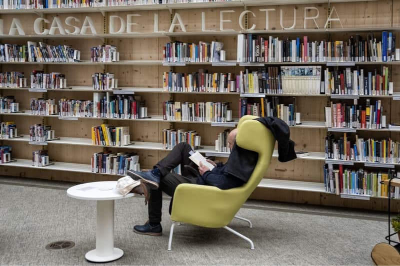 Un home llegeix un llibre a l'espai de lectura de la Biblioteca Gabriel García Márquez