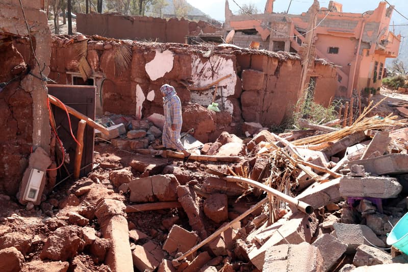 Una mujer mira los escombros de un edificio dañado.