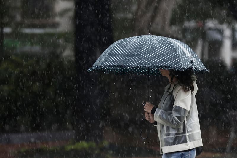 Una dona es protegeix de la pluja amb un paraigua