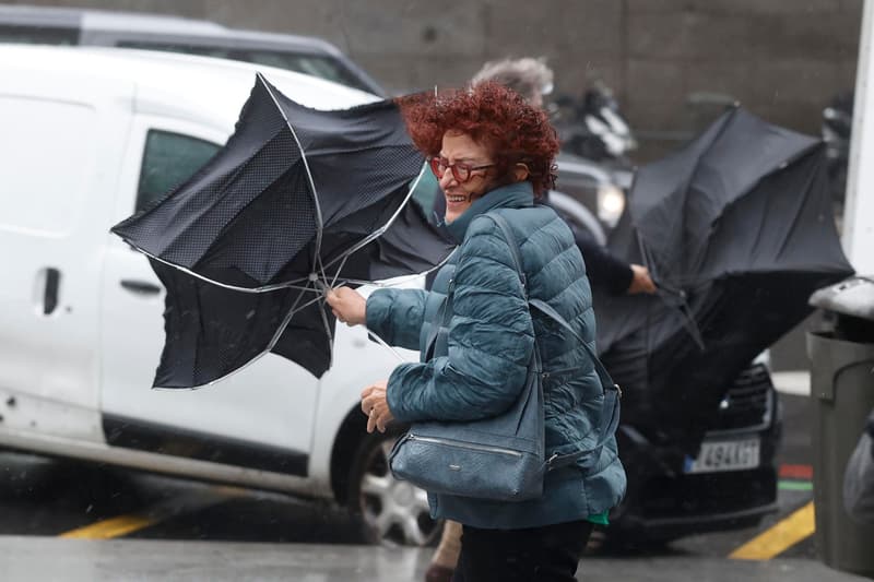 Una dona lluita amb el vent, que li doblega el paraigua durant un temporal de vent