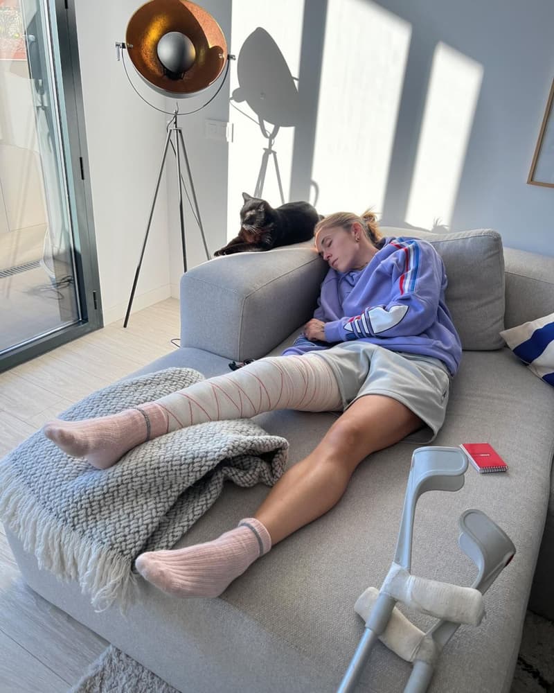 Otra foto de Mapi en el sofá cuando se recuperaba de su última lesión. En el suelo está la misma alfombra blanca que se ve en la parte inferior de la foto con sus padres | Instagram